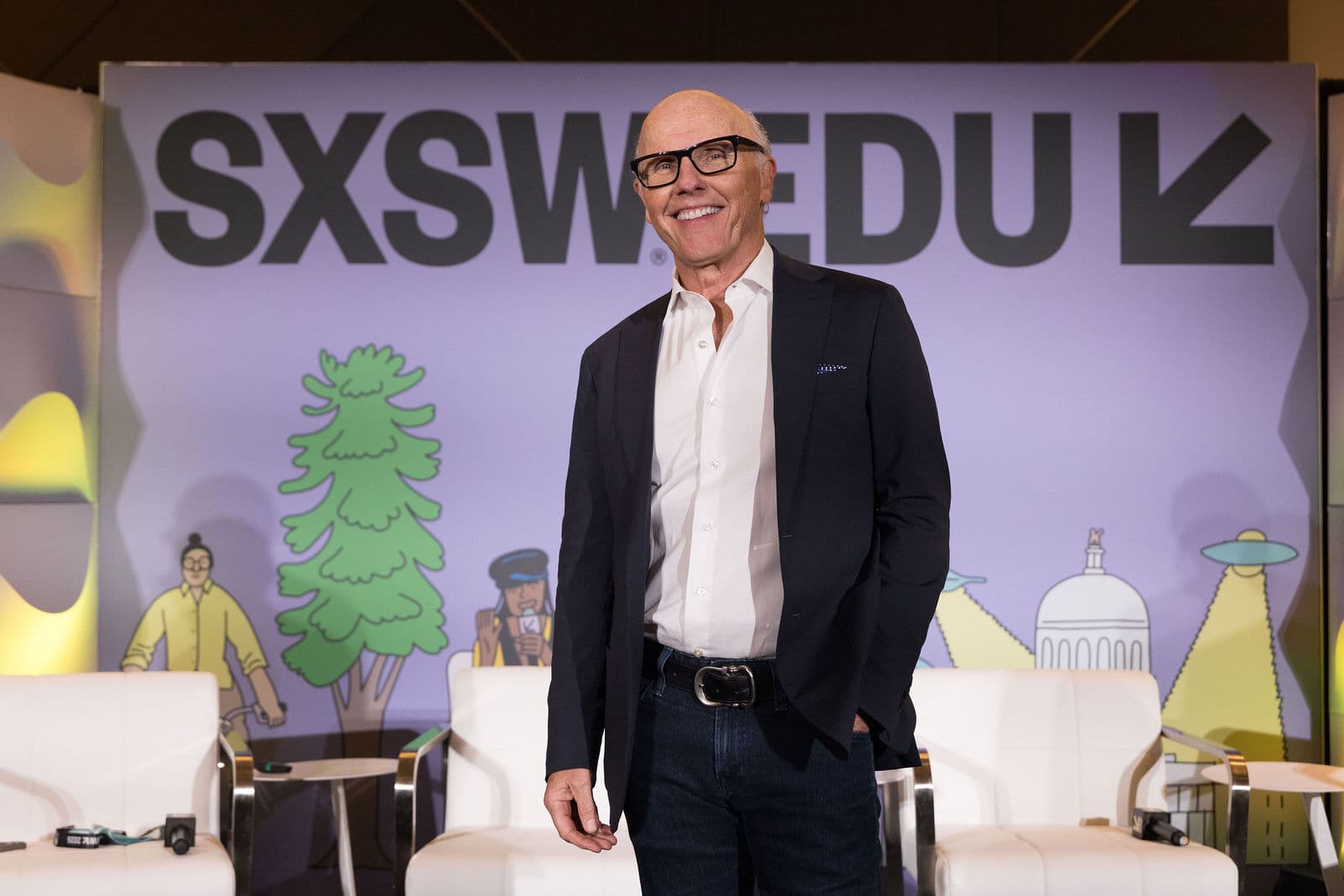 Speaker in a navy blazer on the SXSWEDU stage at the Amerigo Premiere during SXSW 2026 in Austin